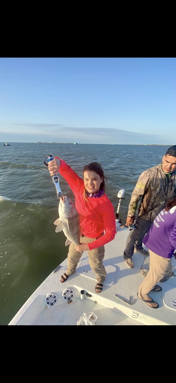 Angler proudly holding a redfish on the bow