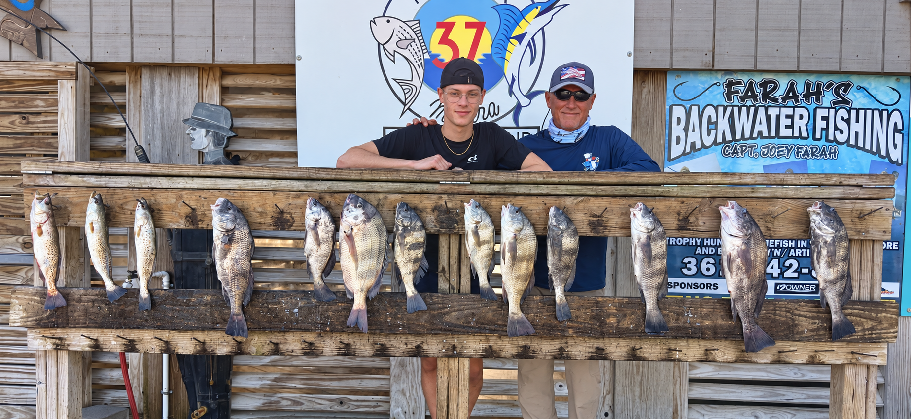 Two men behind a full rack of South Texas fish at Marker 37